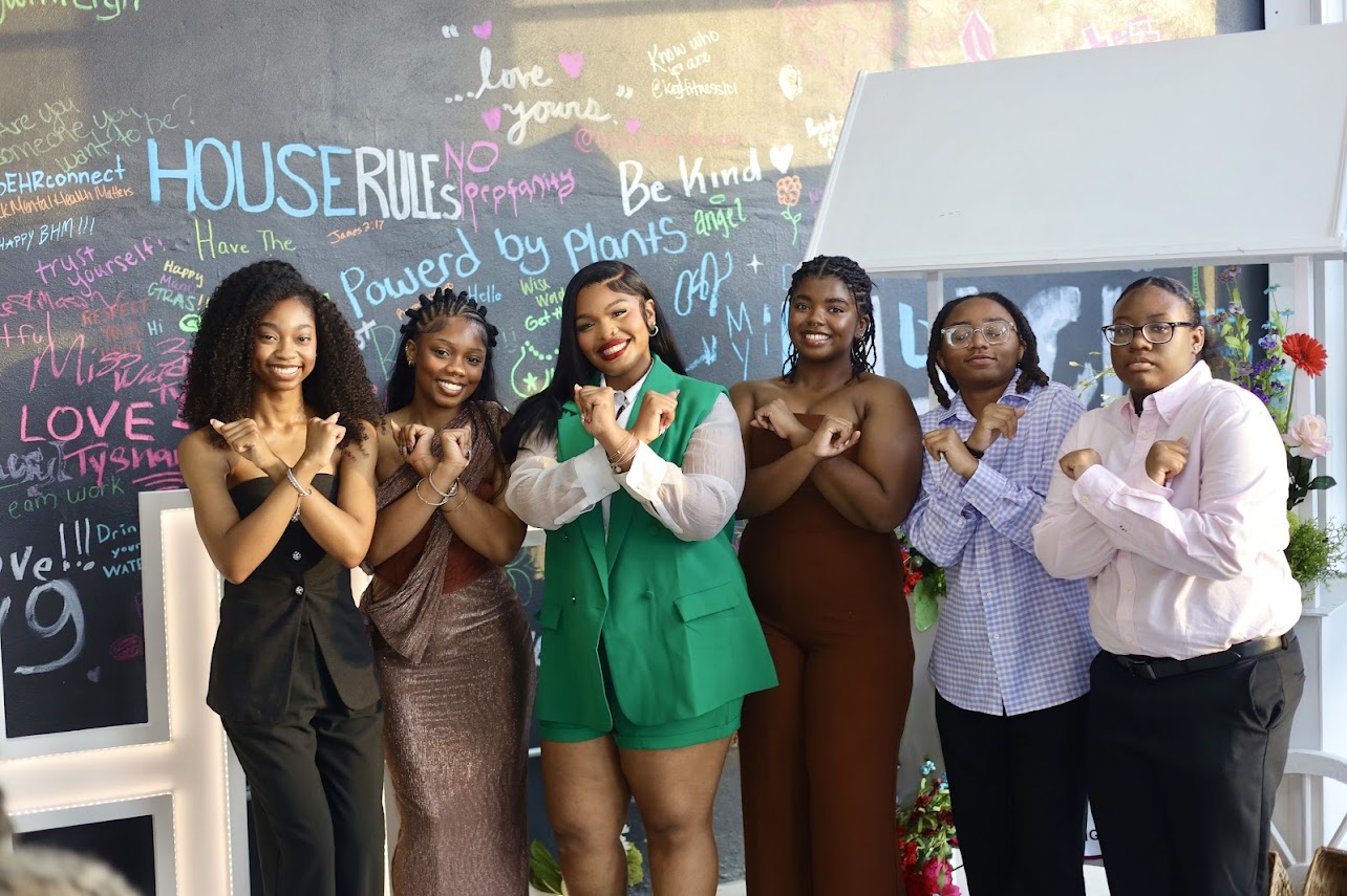 Group portrait in front of the House Rules chalkboard wall