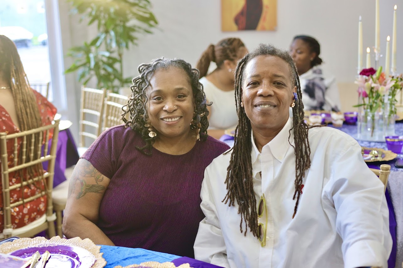 Two guests posing together at a dinner event