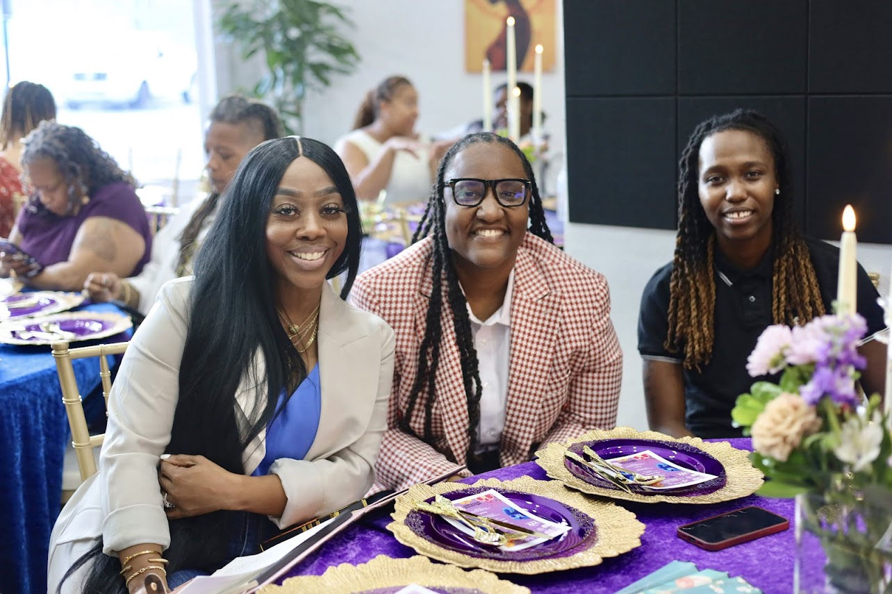 Guests smiling at a purple and gold tablescape
