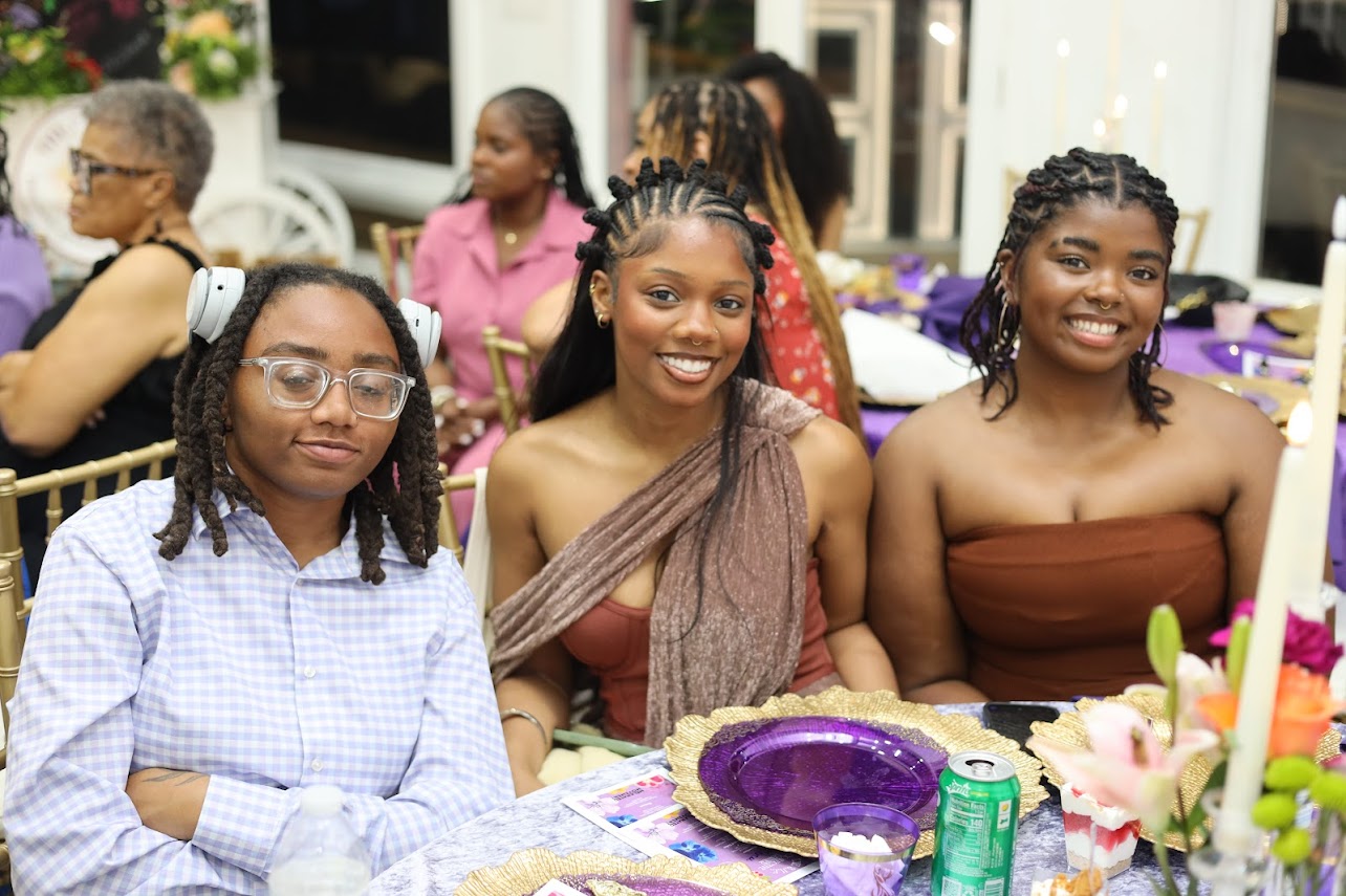Three guests at a candlelit dinner table